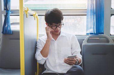 Küçük Asya adam akıllı gülümseme mutlu, ulaşım, turizm ve road trip kavramı ile ise müzik dinlemek giden bir otobüse oturan gezgin.