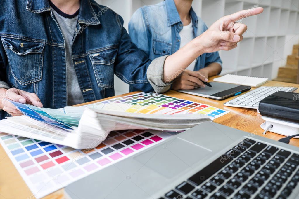 Young creative team having a meeting in creative office, Architectural drawing with work tools and accessories, Color swatch samples chart for selection coloring.