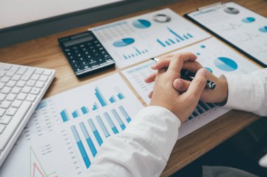 Ofis Büro ve diğer nesnelerin çevresine hesap makinesi ile bir grafik belge mali rapor ve analiz hesaplama yatırım maliyeti üzerinde çalışan iş adamı.