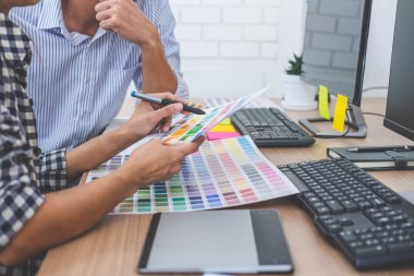 İş yerinde renk seçimi ve grafik tableti üzerinde çalışan iki iş arkadaşı yaratıcı grafik tasarımcısı, seçim renklendirmesi için renk örnekleri grafikleri çizimi.