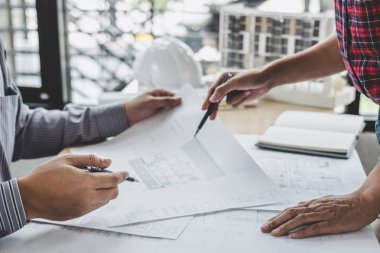 Mimar veya inşaat ve mühendislik araçları çalışma sitesi, inşaat ve yapı kavramı model üzerinde ortak çalışma projesi için toplantı planı üzerinde çalışan mühendis.