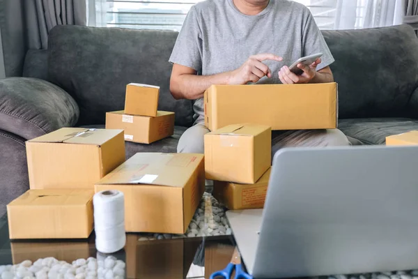 Small business parcel for shipment to client at home, Young entrepreneur SME freelance man working online business by using smart phone with making on purchase order and preparing package product.