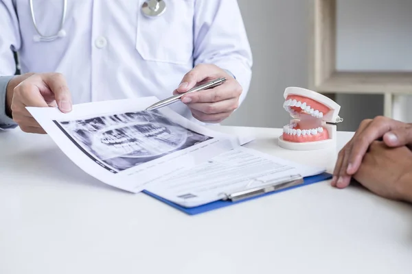 Manliga läkare eller tandläkare skriva rapport arbetar med tand röntgen f — Stockfoto