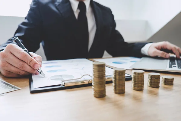 Empresario escribiendo haciendo informe con monedas apiladas arregladas en — Foto de Stock