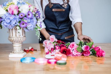 Düzenlenmesi yapay çiçek dekorasyon ev, genç kadını yelek