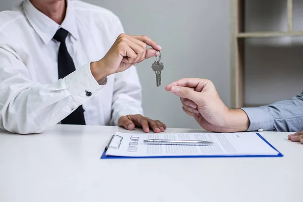 Real estate Sales manager giving keys to customer after signing