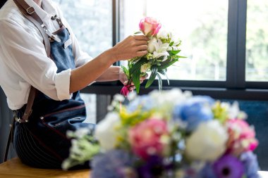 Düzenlenmesi yapay çiçek dekorasyon ev, genç kadını yelek
