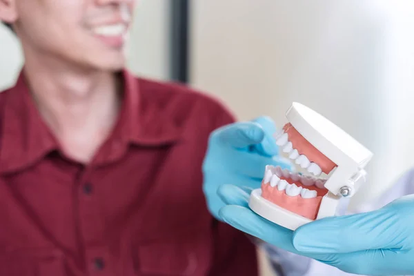 Manliga läkare eller tandläkare som arbetar med käken modell och rekommendera pati — Stockfoto