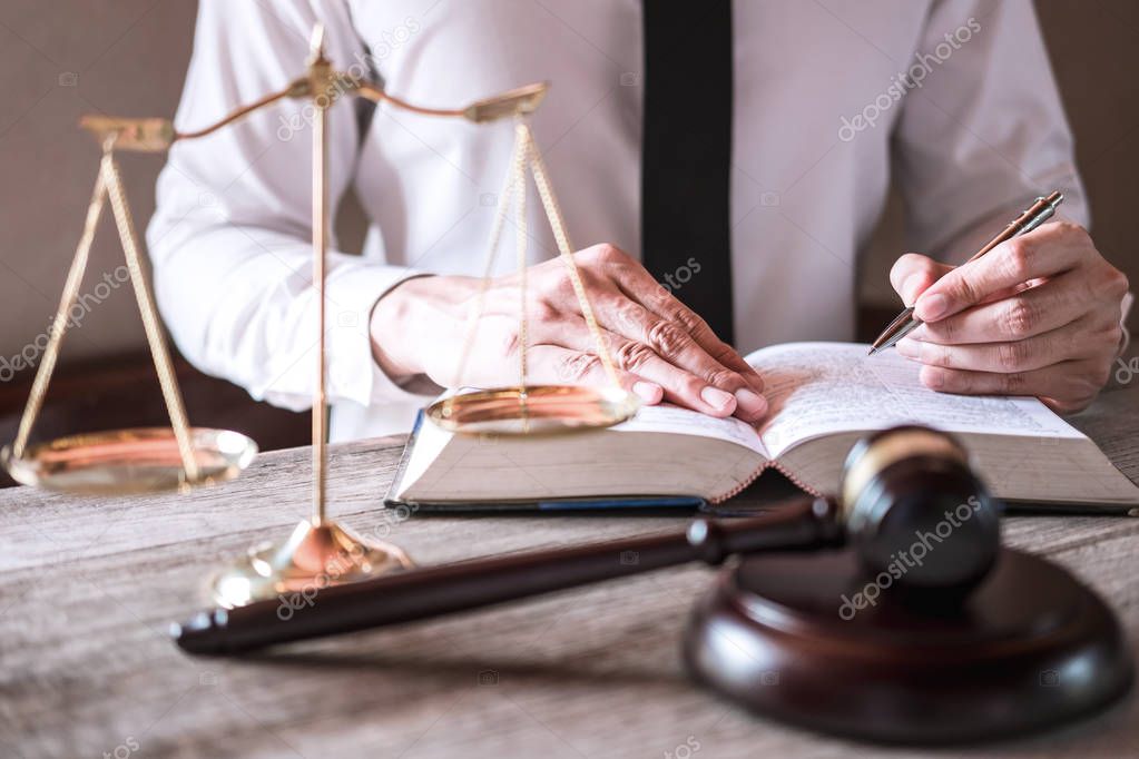 Male lawyer or judge working with Law books, gavel and balance, 