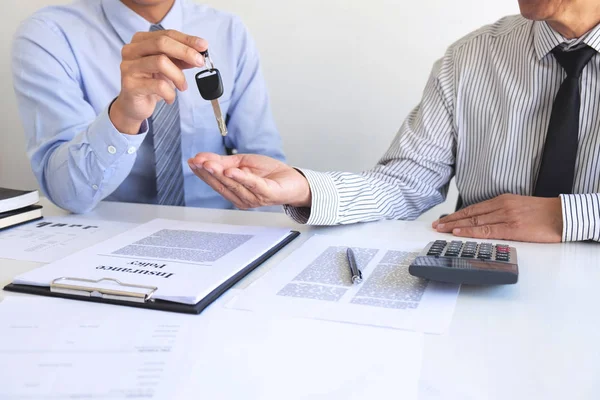 Real estate Sales manager giving keys to customer after signing