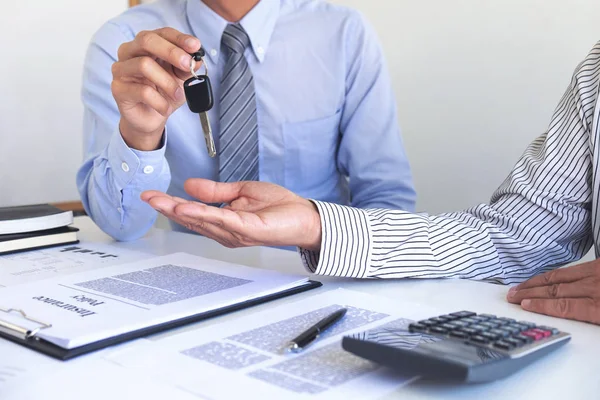 Real estate Sales manager giving keys to customer after signing