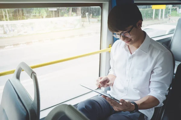 Jovem asiático viajante sentado em um ônibus usando tablet assistir vid — Fotografia de Stock