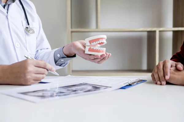 Männlicher Arzt oder Zahnarzt schreibt Bericht über Arbeit mit Röntgenbildern von Zähnen — Stockfoto