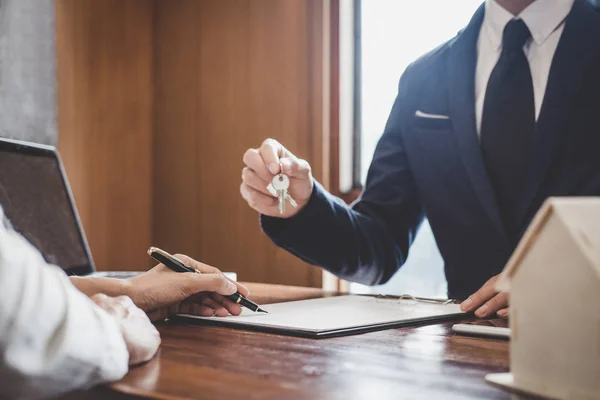 Gerente de vendas arquivando chaves para o cliente depois de assinar contrato de locação — Fotografia de Stock