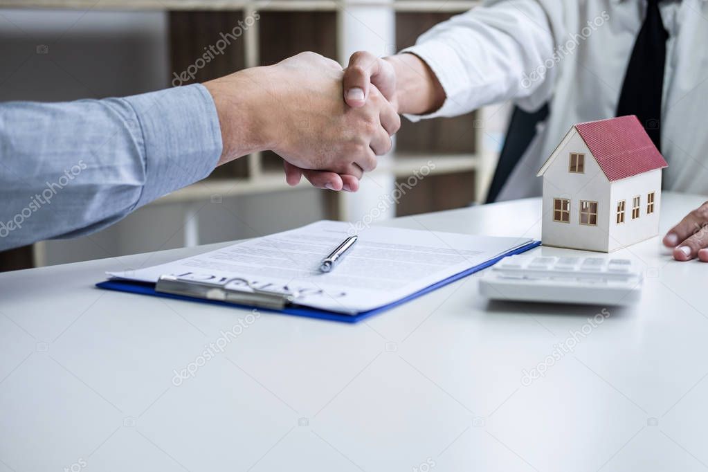 Real estate agent and customers shaking hands together celebrati