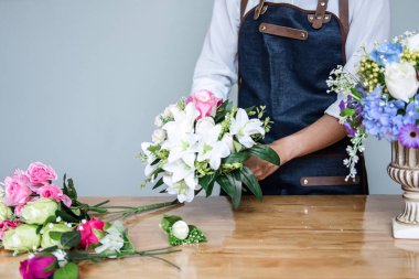 Düzenlenmesi yapay çiçek dekorasyon ev, genç kadını yelek