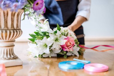 Düzenlenmesi yapay çiçek dekorasyon ev, genç kadını yelek