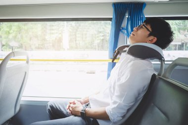 Bir otobüse oturan ve pill uyuyan genç Asyalı adam traveler