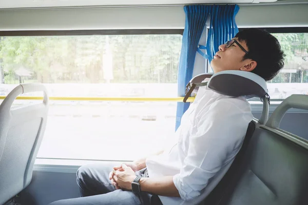 Young Asian man traveler sitting on a bus and sleeping with pill