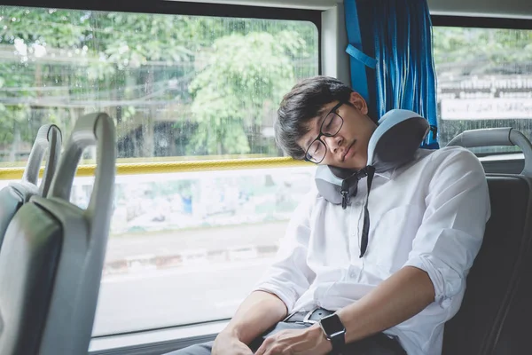 Young Asian man traveler sitting on a bus and sleeping with pill