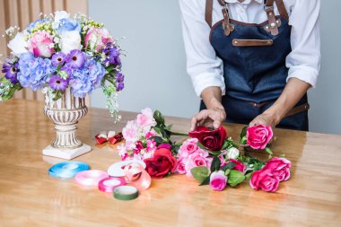 Düzenlenmesi yapay çiçek dekorasyon ev, genç kadını yelek