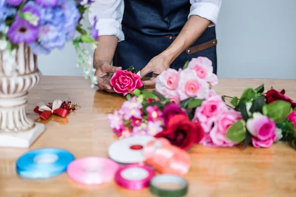 Organiser la décoration de gilet de fleurs artificielles à la maison, Jeune femme — Photo