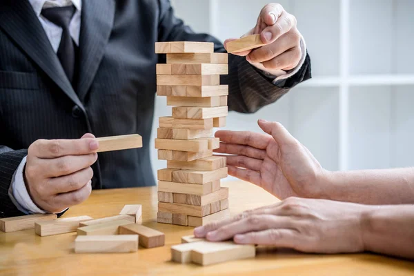 Images of hand of businesspeople placing and pulling wood block — Stock Photo, Image