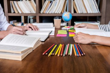 Kitaplıktaki masada oturan lise veya Üniversite öğrenci grubu 