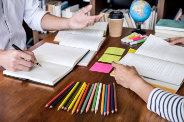 Kitaplıktaki masada oturan lise veya Üniversite öğrenci grubu 