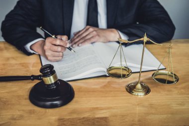 Erkek avukat ya da yargıç ile sözleşme kağıtları, hukuk kitapları çalışma ve
