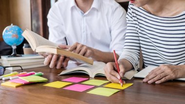 Kitaplıktaki masada oturan lise veya Üniversite öğrenci grubu 