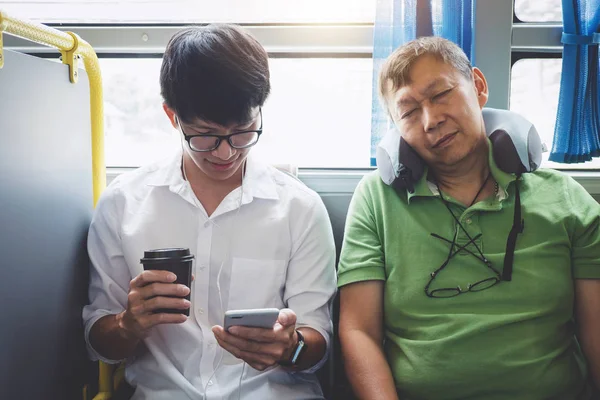 Jovem asiático viajante sentado em um ônibus usando smartphone para l — Fotografia de Stock