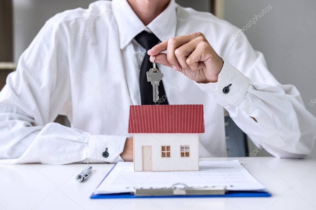 Real estate agent Sales manager holding filing keys to customer 