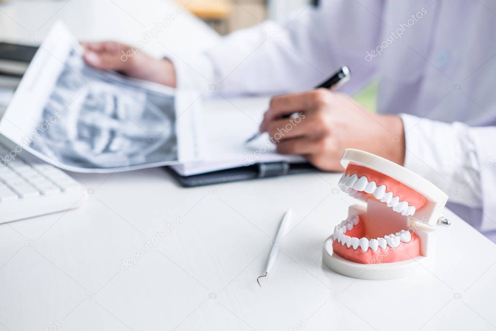 Male doctor or dentist working with patient tooth x-ray film, mo