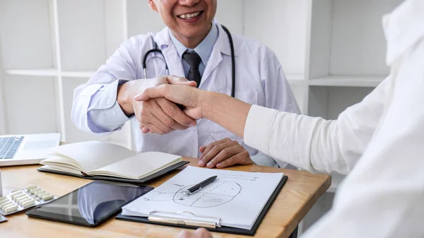 Profissional Médico masculino em casaco branco apertando a mão com feminino — Fotografia de Stock