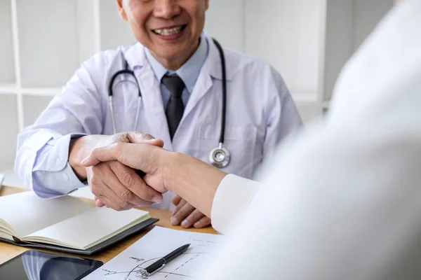 Professionale Medico di sesso maschile in cappotto bianco stringendo la mano con femmina — Foto Stock