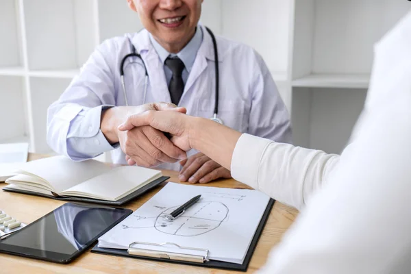 Professionale Medico di sesso maschile in cappotto bianco stringendo la mano con femmina — Foto Stock