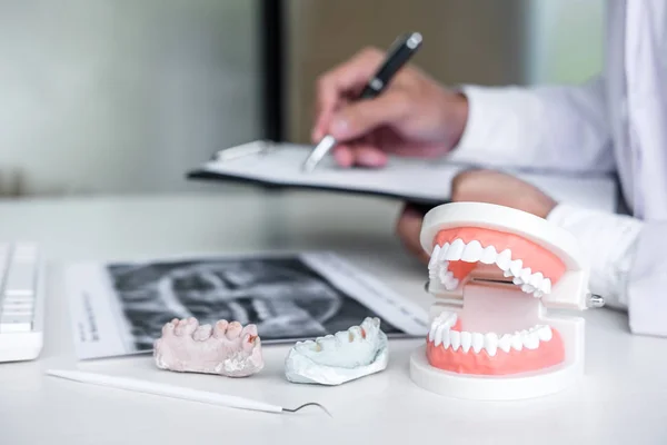 Manliga läkare eller tandläkare skriva rapport arbetar med tand röntgen f — Stockfoto