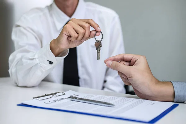 Gerente de vendas imobiliárias dando chaves para o cliente após a assinatura — Fotografia de Stock