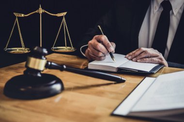 Erkek avukat ya da yargıç ile sözleşme kağıtları, hukuk kitapları çalışma ve