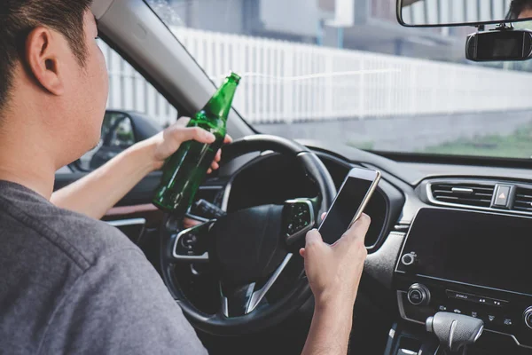 Joven asiático hombre conduce un coche con borracho un botella de cerveza y usi —  Fotos de Stock