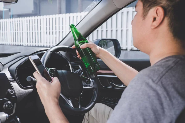 Jeune homme asiatique conduit une voiture avec ivre une bouteille de bière et usi — Photo