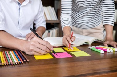 Kitaplıktaki masada oturan lise veya Üniversite öğrenci grubu 