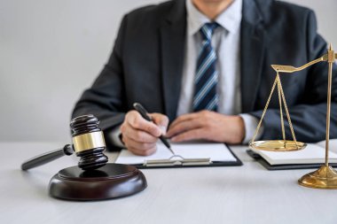 Erkek avukat ya da yargıç ile sözleşme kağıtları, hukuk kitapları çalışma ve
