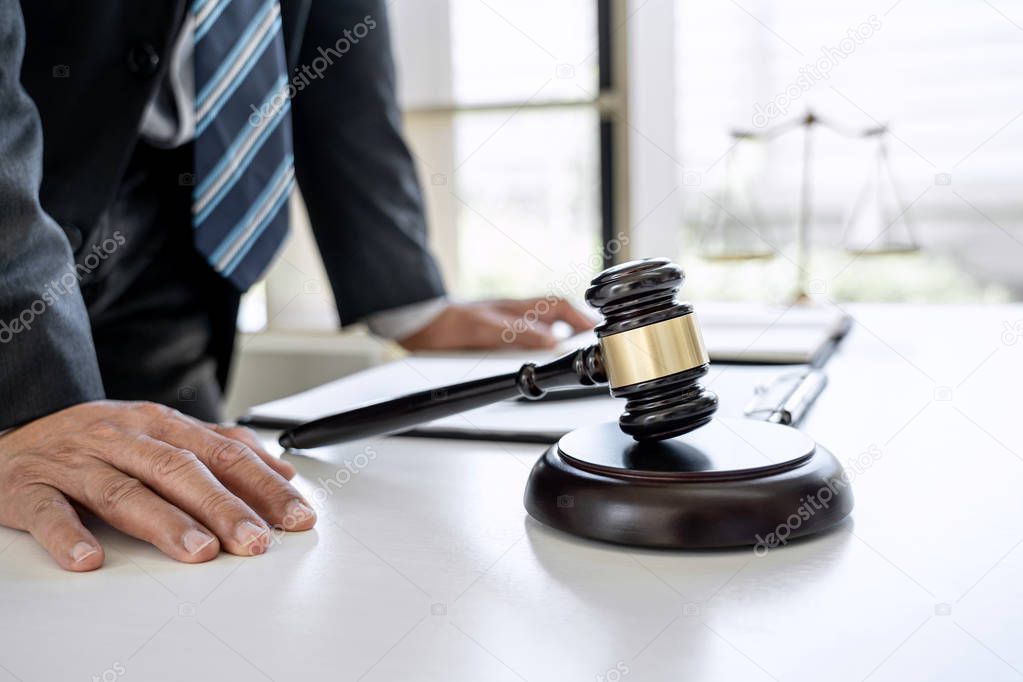 Male lawyer or judge working with contract papers, Law books and