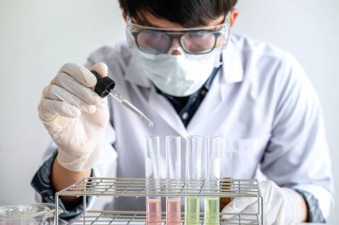 Biyokimya laboratuvarı araştırması. Kimyager laboratuvarda kimyasal sıvı içeren ekipman ve bilimsel deneylerle numune analiz ediyor..