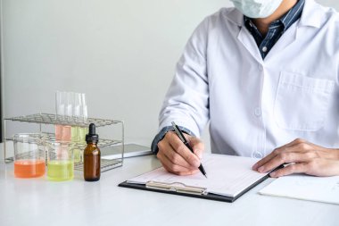 Biyokimya laboratuvarı araştırması. Kimyager laboratuvarda kimyasal sıvı içeren ekipman ve bilimsel deneylerle numune analiz ediyor..