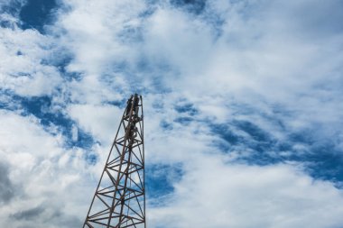 İnşaat işçisi inşaat alanında merdivenle çalışıyor ve güzel bir bulut, gökyüzü arkaplanı..