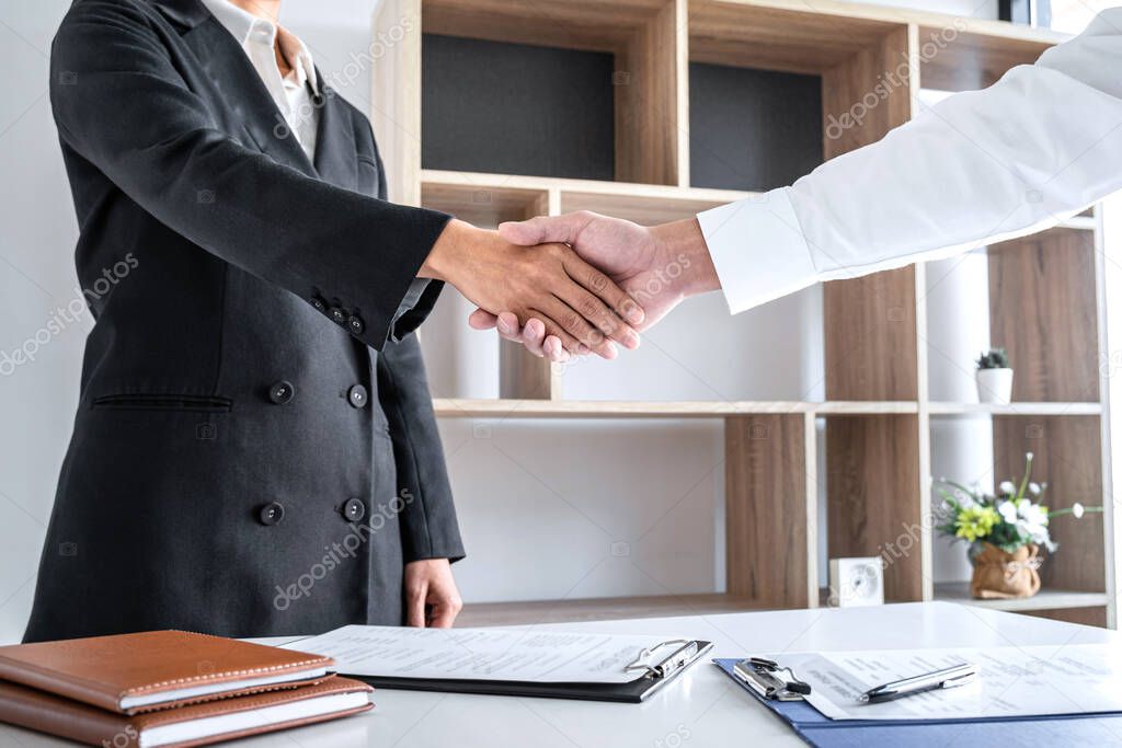 Greeting new colleagues, Handshake while job interviewing, male candidate shaking hands with Interviewer or employer after a job interview, employment and recruitment concept.