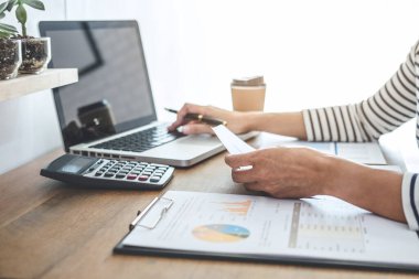 Kadın muhasebeci hesapları, hesap makinesi ve dizüstü bilgisayarı ile mali grafik verilerinin denetlenmesi ve analizi, finansman, muhasebe, finans, ekonomi, tasarruf bankacılığı kavramı.